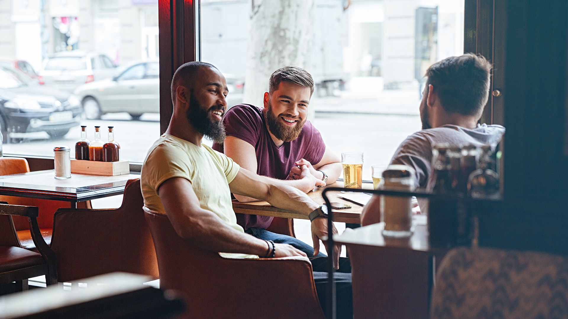 Happy male friends talking in beer pub